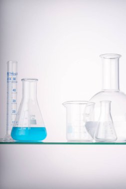 Laboratuvar ekipmanları deney tüpleri ve farklı gruplarda arka plan ışığı olan mataralar. Ürün sunumu için alan.