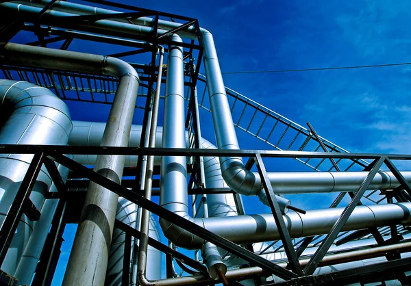 Průmyslová zóna, ocelové potrubí a ventily proti modré obloze — Stock fotografie