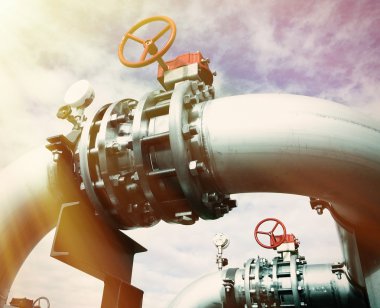 Mavi gökyüzüne karşı sanayi bölgesi, çelik boru hatları ve vanalar