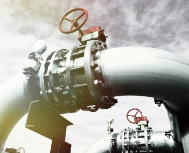 Mavi gökyüzüne karşı sanayi bölgesi, çelik boru hatları ve vanalar