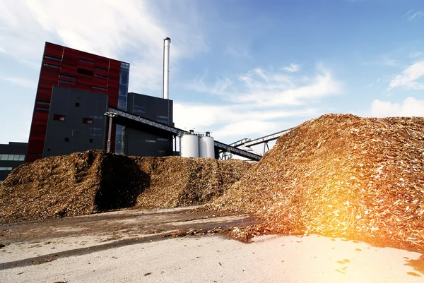 Biokraftwerk mit Holzbrennstofflagerung vor blauem Himmel — Stockfoto