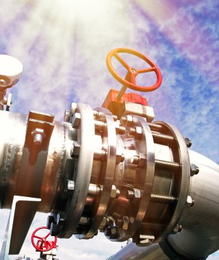 Mavi gökyüzüne karşı sanayi bölgesi, çelik boru hatları ve vanalar