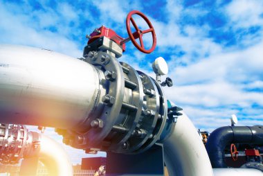 Mavi gökyüzüne karşı sanayi bölgesi, çelik boru hatları ve vanalar