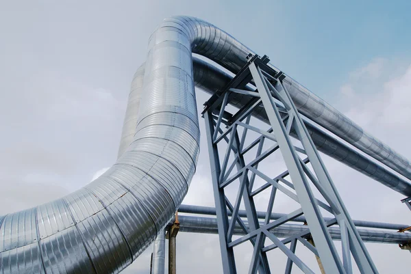 Zona industrial, tuberías de acero y válvulas contra el cielo azul — Foto de Stock