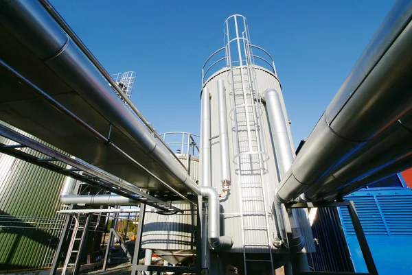 Zona industrial, tuberías de acero y válvulas contra el cielo azul — Foto de Stock