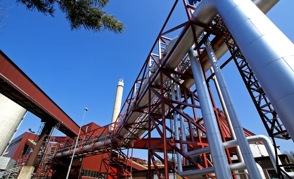 Zona industrial, tuberías de acero y válvulas contra el cielo azul —  Fotos de Stock