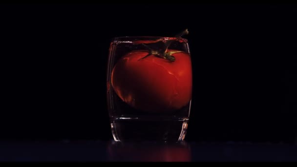 Dricksglas Med Stor Tomat Faller Och Stänk Klart Vatten Slow — Stockvideo