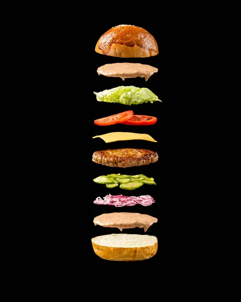 Siyah arka planda yüzen hamburger malzemeleri