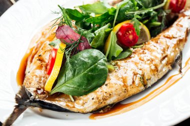 Taze yeşillik ve limonla doldurulmuş kızarmış balık.