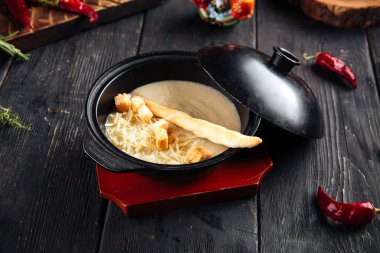 Kremalı çorba, kraker ve rendelenmiş peynir.