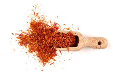 Tahta bir kepçenin içindeki izole safran yığını.