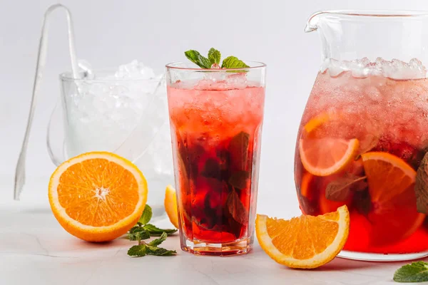 Vue latérale sur la limonade aux baies rouges dans une cruche et un verre — Photo