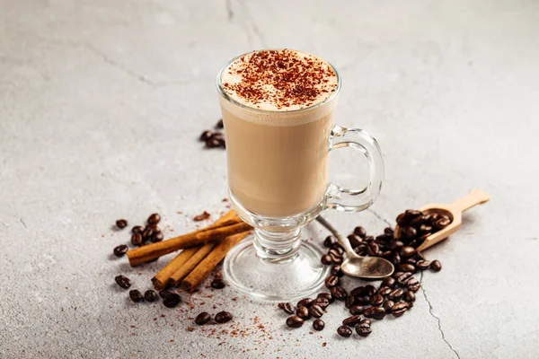 Украшенный кофе латте с какао в стеклянной кружке — стоковое фото
