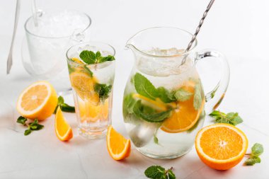 Sürahi ve bardakta portakal ve naneli limonata.