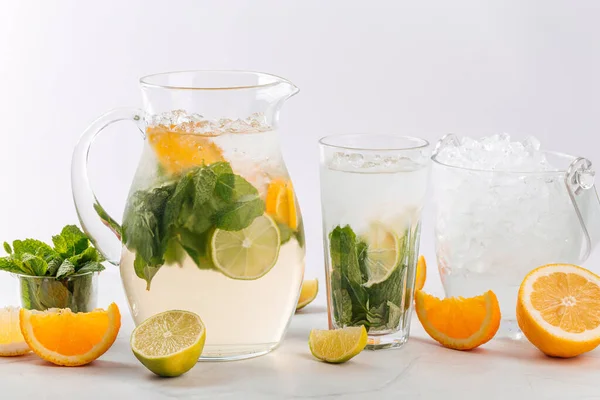 Orange and lime lemonade in a jug and glass — Stock Photo, Image