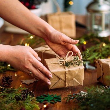 Erkek el, köknar dallı bir hediye kutusu tutuyor.