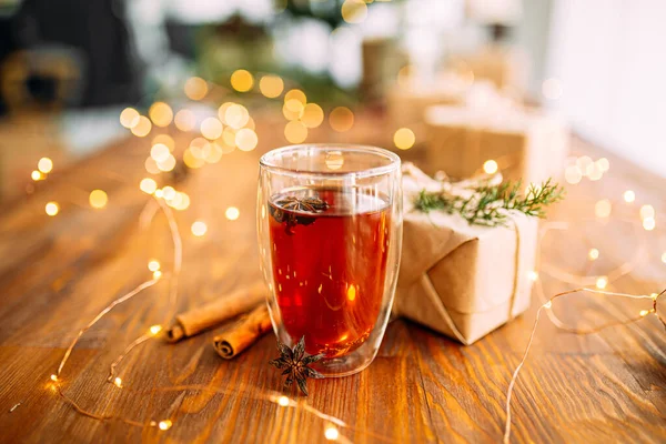 Tasse en verre de thé avec anis étoilé et guirlande lumière — Photo