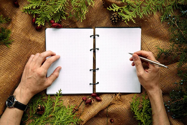 Mockup em mãos masculinas vai escrever em um caderno — Fotografia de Stock