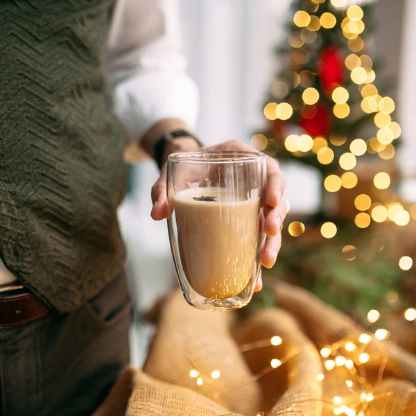 Männliche Hand hält Kaffee mit festlichem Kranz — Stockfoto