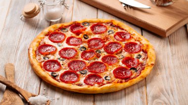 Salamlı ve zeytinli taze fırınlanmış pepperoni pizza.