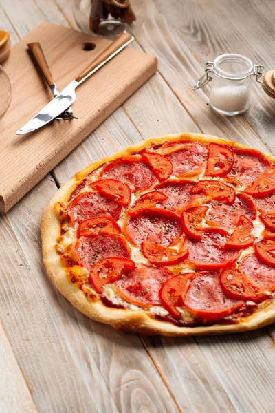 Domatesli jambonlu pizza ve kurutulmuş otlar.