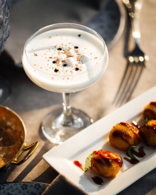 Masada köpüklü alkollü ekşi kokteyl.