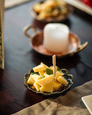 Aperatif peynir tabağı ahşap masada.