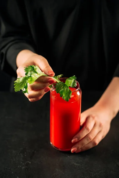 Woman making bloody mary cocktail with celery — Stock Photo, Image