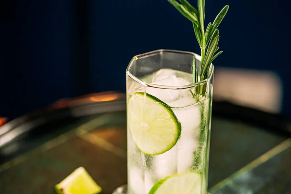 Cóctel gin tonic de primer plano con romero y lima —  Fotos de Stock