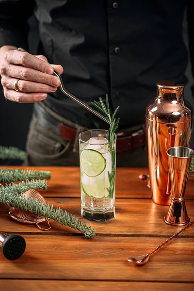 Hombre haciendo cóctel gin tonic fresco con lima — Foto de Stock