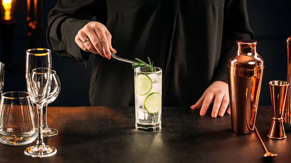 Mujer haciendo cóctel gin tonic fresco con lima — Foto de Stock