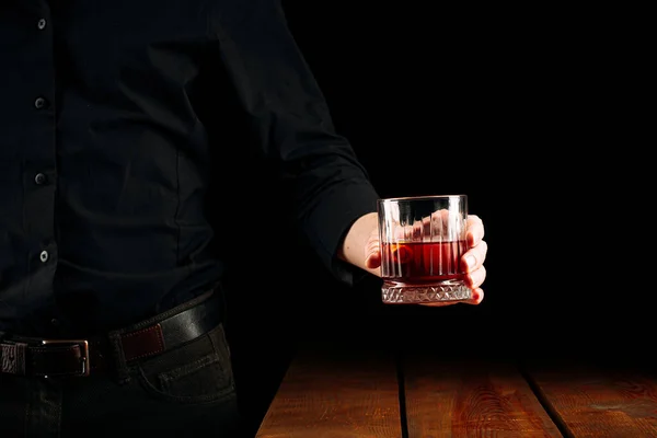 Hombre sosteniendo una copa de cóctel negroni — Foto de Stock