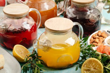 Mavinin üzerinde cam kaplarda çeşitli meyve çayları.