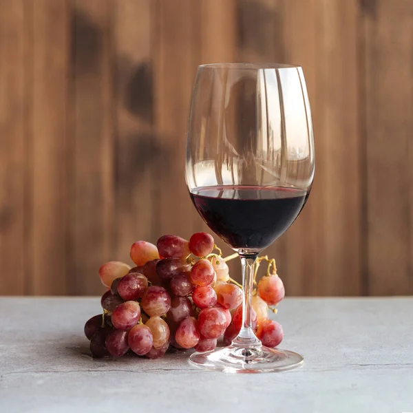 Side view on a glass of red wine with grapes Stock Photo