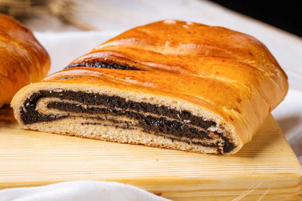 Closeup on cut poppy seed bun on the wooden board — Stock Photo, Image