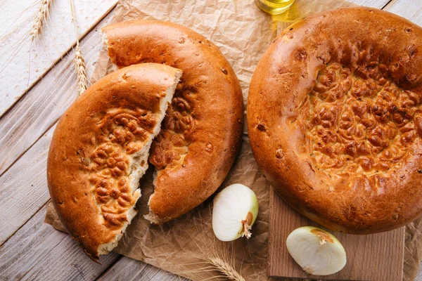 Bovenaanzicht op gebroken vers gebakken ui plat brood — Stockfoto