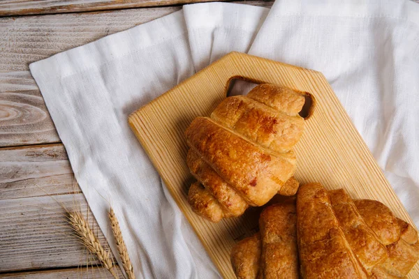 Pohled shora na francouzské croissanty na dřevěné řezací desce — Stock fotografie