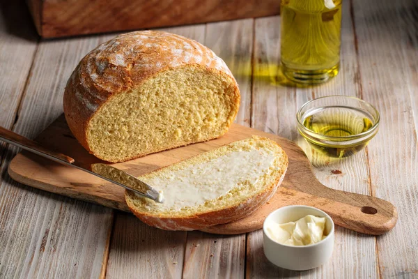 Нарежьте буханку хлеба с оливковым маслом — стоковое фото