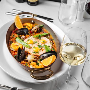 İspanyol deniz ürünleri paella 'sı ve bir kadeh şarap.