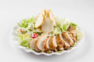 Beyaz üzerine Rus usulü sezar tavuk salatası.