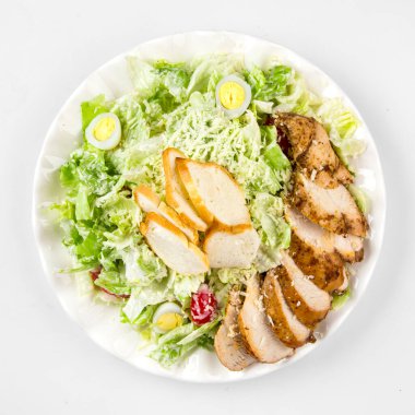 Beyaz üzerine Rus usulü sezar tavuk salatası.