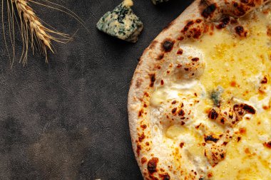 Süslü arka planda dört peynirli pizza.