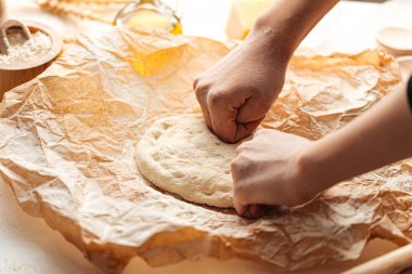 Pizza pişirmek için hamur yoğuruyorum. 
