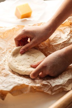 Pizza pişirmek için hamur yoğuruyorum. 