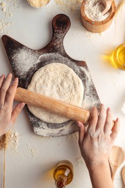 Hamuru rulo raptiyeyle pizza için yuvarlıyorum.