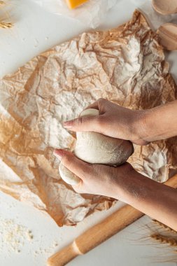 Pizza pişirmek için hamur yoğuruyorum. 