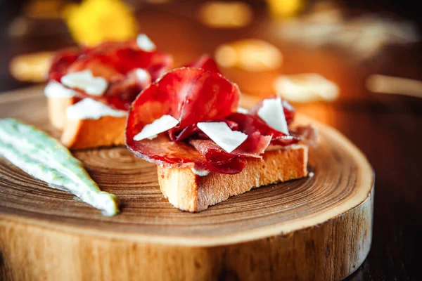 Closeup on prosciutto bruschetta platter and sauce — Stock Photo, Image