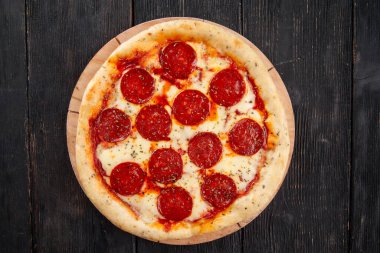 Ahşap arka planda taze fırında peponi pizza.