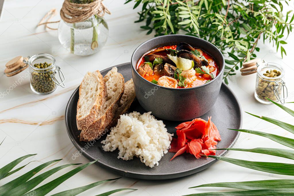 Tom yam soup with seafood and rice with toasts