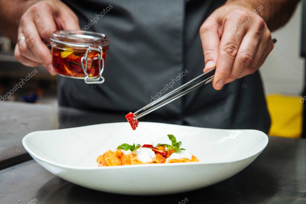 Restaurant chef cooking italian food with tomatoes